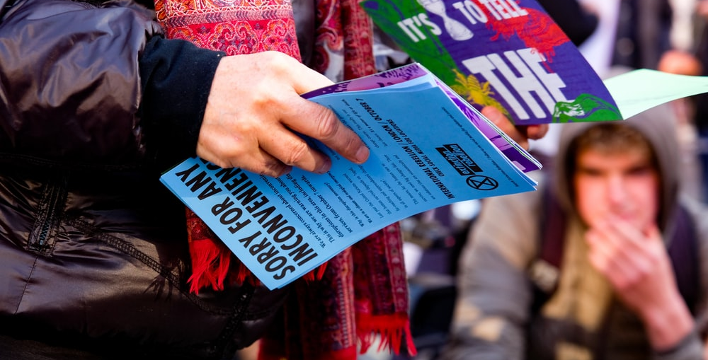 A person holding a bunch of flyers