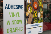 Self-adhesive vinyl high-quality printed banner displayed on a glass storefront window