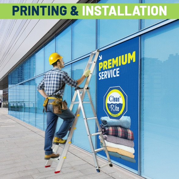 A person installing a vinyl banner on a window