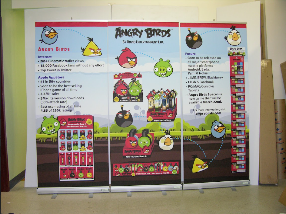 A branded retractable pull-up banner displayed next to promotional materials at an indoor event