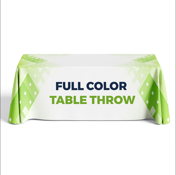 A full-colour branded table throw draped over a folding table at a trade show display