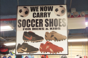Promotional graphic featuring soccer shoes in a retail-style display
