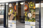 Food-themed adhesive window graphics installed across a restaurant storefront