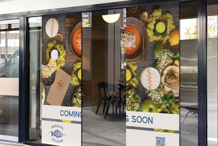 Food-themed adhesive window graphics installed across a restaurant storefront